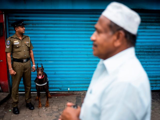 A policeman stands guard outside a mosque during Friday noon prayer in Colombo on April 26, 2019, following a series of bomb blasts targeting churches and luxury hotels on Easter Sunday in Sri Lanka. - Authorities in Sri Lanka on April 25 lowered the death toll in a spate of …