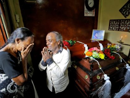 Baby Joseph Gomes prays standing next to coffins of his family members killed in the Easter Sunday bombings in Colombo, Sri Lanka, Tuesday, April 23, 2019. Gomes lost five members of his family. The six near-simultaneous attacks on three churches and three luxury hotels and three related blasts later Sunday …