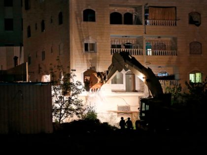 An Israeli army buldoser destroys the home of Arafat Irfaiya, a 29-year-old Palestinian accused of killing a young Israeli woman last February, in the Israeli-occupied West Bank town of Hebron, on April 19, 2019. - The body of 19-year-old Ori Ansbacher was found on February 7 south of Jerusalem and …