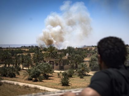 A fighter loyal to the internationally-recognised Government of National Accord (GNA) watches as smoke rises in the distance during clashes with forces loyal to strongman Khalifa Haftar, in Espiaa, about 40 kilometres (25 miles) south of the Libyan capital Tripoli on April 29, 2019. - Fierce fighting for control of …
