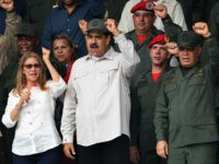 Venezuelan President Nicolas Maduro (2-L), his wife Cilia Flores (L) and Defence Minister Vladimir Padrino (R) gesture during a military parade to commemorate the 17th anniversary of a failed 2002 coup d'état against former leader Hugo Chavez, at Fuerte Tiuna Military Complex, in Caracas on April 13, 2019. (Photo by …