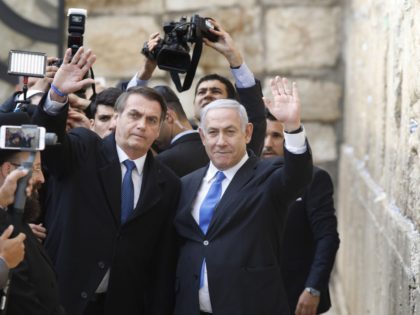 Brazilian President Jair Bolsonaro (L) and Israeli Prime Minister Benjamin Netanyahu wave to the press during a visit to the Western wall, the holiest site where Jews can pray, in the Old City of Jerusalem on April 1, 2019. - Bolsonaro visited the Western Wall alongside Netanyahu today, becoming the …