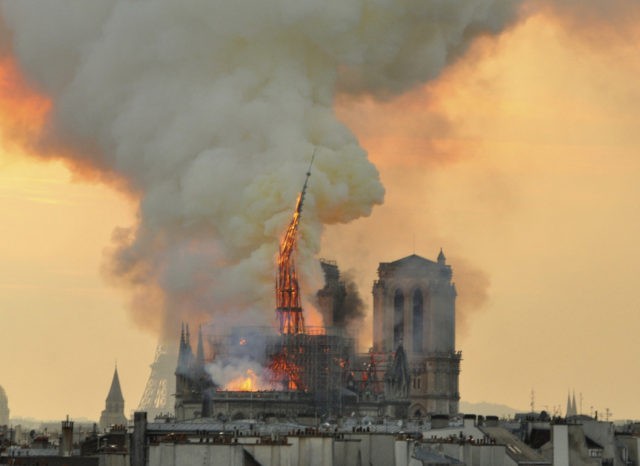 APTOPIX France Notre Dame Fire In this image made available on Tuesday April 16, 2019 flames and smoke rise from the blaze as the spire starts to topple on Notre Dame cathedral in Paris, Monday, April 15, 2019. An inferno that raged through Notre Dame Cathedral for more than 12 hours destroyed its spire and its roof but spared its twin medieval bell towers, and a frantic rescue effort saved the monument's "most precious treasures," including the Crown of Thorns purportedly worn by Jesus, officials said Tuesday. (AP Photo/Thierry Mallet) The Associated Press