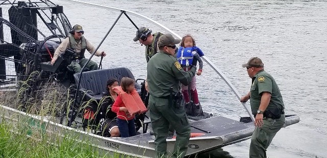 Del Rio Station marine agents transfer a rescued migrant family to ground-based agents for transportation after rescuing them from a stranded makeshift raft. (Photo: U.S. Border Patrol/Del Rio Sector)