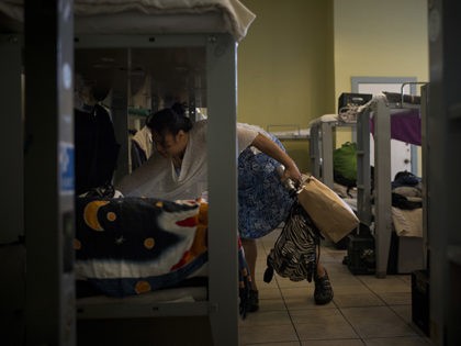 Stella Tatola, a homeless woman staying in a women's shelter at the Sanctuary, cleans her bed while getting ready to start her day, Tuesday, Oct. 24, 2017, in San Francisco. (AP Photo/Jae C. Hong)