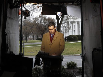 CNN's Jim Acosta waits to make a report with the White House in the background, Friday Mar