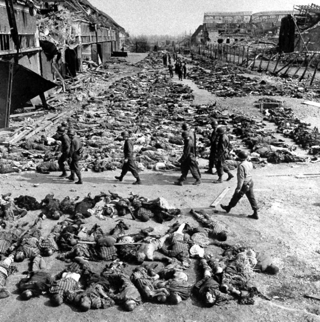 In this image provided by the U.S. Army Signal Corps, American soldiers walk by row after row of corpses lying on the ground beside barracks at the Nazi concentration camp at Nordhausen, Germany, April 17, 1945. The camp is located about 70 miles west of Leipzig. As the camp was liberated on April 12, the U.S. Army found more than 3000 unburied bodies, and a handful of survivors.(AP Photo/U.S. Army Signal Corps)