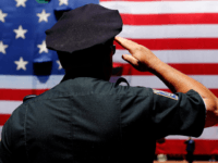 A police officer salutes during the National Anthem before the first game of a doubleheader between the Baltimore Orioles and the Boston Red Sox at Fenway Park on July 5, 2014 in Boston, Massachusetts. (Photo by Jim Rogash/Getty Images)