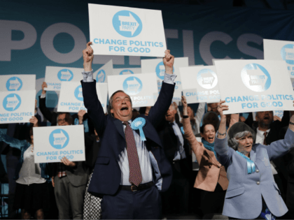 Brexit Party leader Nigel Farage (C) holds up a placard at the end of a European Parliament election campaign rally at Olympia London, west London on May 21, 2019. (Photo by Tolga AKMEN / AFP) (Photo credit should read TOLGA AKMEN/AFP/Getty Images)