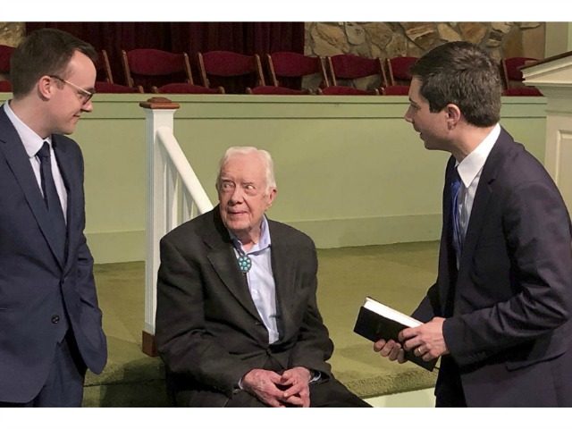 Democratic presidential candidate Pete Buttigieg and his husband, Chasten, speak with former President Jimmy Carter on Sunday in Plains, Georgia. | Paul Newberry/AP Photo