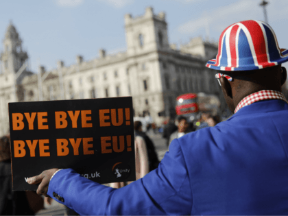 Pro-Brexit activist Joseph Afrane holds a placard as he demonstrates outside the Houses of Parliament in Westminster, London on March 28, 2019. - Faced with losing all control over the Brexit process, British Prime Minister Theresa May looks to have played her final card by announcing she will step down …