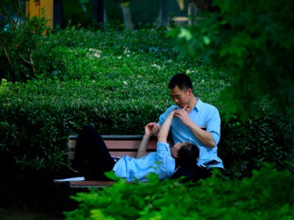 A couple chats on a bench in Beijing on May 29, 2018. (Photo by WANG ZHAO / AFP) (Photo cr