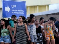 Family members of inmates are pictured praying in front of the Puraquequara Prison facility at Bela Vista community, Puraquequara neighborhood at the city of Manaus, Amazonas state on May 27, 2019. - At least 40 inmates were killed in four jails in northern Brazil on Monday, authorities said, in the …