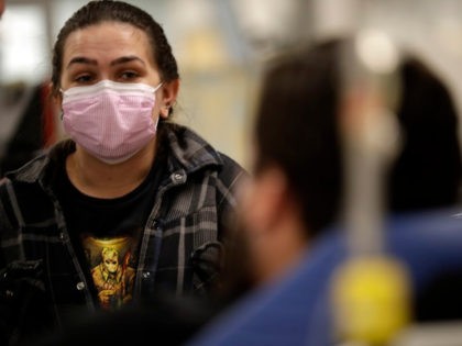 In this Jan. 10, 2018 photo, Torrey Jewett looks on as her roommate Donnie Cardenas recovers from the flu at the Palomar Medical Center in Escondido, Calif. Cardenas, a San Diego County resident, said he was battling a heavy cough for days before a spike his temperature sent him into …
