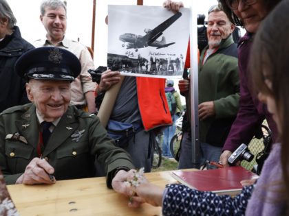 Former Berlin Airlift pilot Gail Halvorsen from the US (L) receives flowers from a girl during a ceremony at the Tempelhofer Feld, a former airfield in Berlin, on May 11, 2019. - The Berlin Braves sports club dedicated their baseball and softball fields to Gail Halvorsen on the sidelines of …