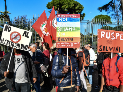 People, including employees of the country's social and reception centers and members of anti-racism associations, march during a demonstration against the government's social politics, its recent decree restricting the right to asylum, and against racism on November 10, 2018 in downtown Rome. - The placards read (From L) "No to …