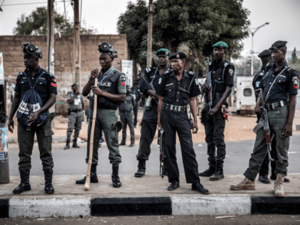 Nigerian police monitor an area where All Progressives Congress Party (APC) supporters are celebrating after initial results were released by the Nigerian Independent National Electoral Commission (INEC) in Kano, on February 25, 2019, two days after general elections. - Nigeria's main opposition on February 25 accused the ruling party of …