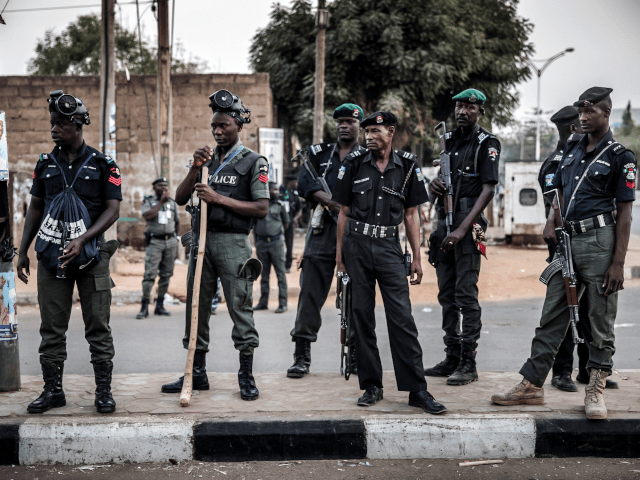 Nigerian police monitor an area where All Progressives Congress Party (APC) supporters are