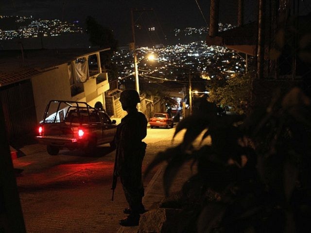 ACAPULCO, MEXICO - MARCH 03: A Mexican army soldier stands guard at a suspected drug-related murder site March 3, 2012 in Acapulco, Mexico. A forensics team excavated five corpses from the floor of an abandoned house. Officials said the five victims were apparently buried alive in concrete. Drug violence has …