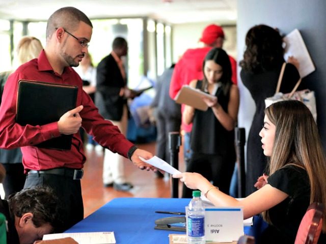 FILE- In this Jan. 30, 2018, file photo, an employee of Aldi, right, takes an application from a job applicant at a JobNewsUSA job fair in Miami Lakes, Fla. On Thursday, Jan. 3, 2019, payroll processor ADP reports how many jobs private employers added in December. (AP Photo/Lynne Sladky