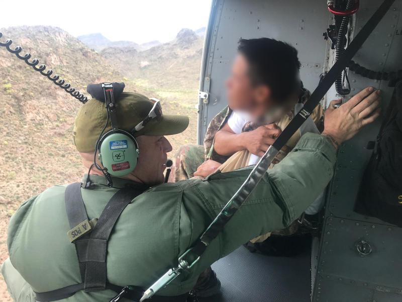 A Pinal County Sheriff's Office helicopter aircrew assist U.S. Border Patrol agents in rescuing a Honduran migrant suffering a possible bone fracture. (Photo U.S. Border Patrol/Tucson Sector)