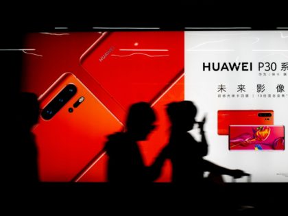 Commuters walk by the new Huawei P30 smartphone advertisement on display inside a subway station in Beijing Monday, May 13, 2019. China's intensified tariff war with the Trump administration is threatening Beijing's ambition to transform itself into the dominant player in global technology. (AP Photo/Andy Wong)