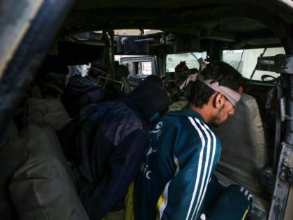 Blindfolded suspected Islamic State group (IS) jihadists sit in a Humvee, after they were