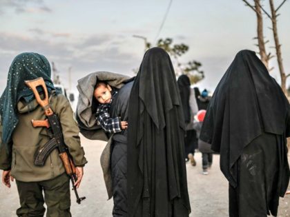 Veiled women reportedly associated with ISIS walk under the supervision of a female fighter from the Syrian Democratic Forces in northeastern Syria on Sunday. Over the weekend, President Trump demanded European allies repatriate their citizens captured as ISIS fighters. Bulent Kilic /AFP/Getty Images