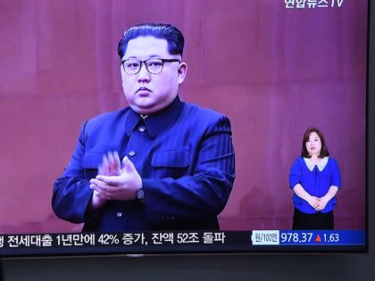 A man watches a television news screen showing North Korean leader Kim Jong Un at a railwa