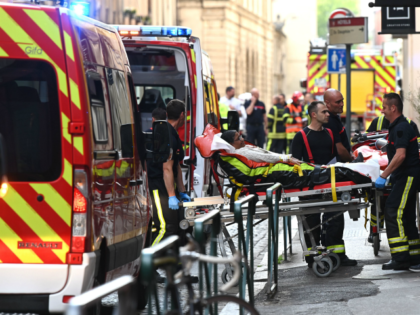 TOPSHOT - Emergency workers stretcher a woman to a waiting ambulance after a suspected package bomb blast along a pedestrian street in the heart of Lyon, southeast France, the local prosecutors' office said on May 24, 2019. - Several people were wounded by a suspected package bomb blast on a …