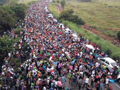 Members of a US-bound migrant caravan stand on a road after federal police briefly blocked