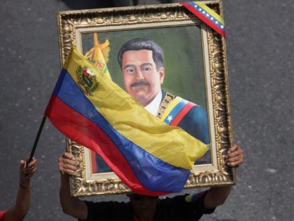 Supporters of Venezuelan President Nicolas Maduro carry a portrait of him during a rally in Caracas, Venezuela, Wednesday, May 1, 2019. Opposition leader Juan Guaidó called for Venezuelans to fill streets around the country Wednesday to demand President Nicolás Maduro's ouster. Maduro is also calling for his supporters to rally.(AP …