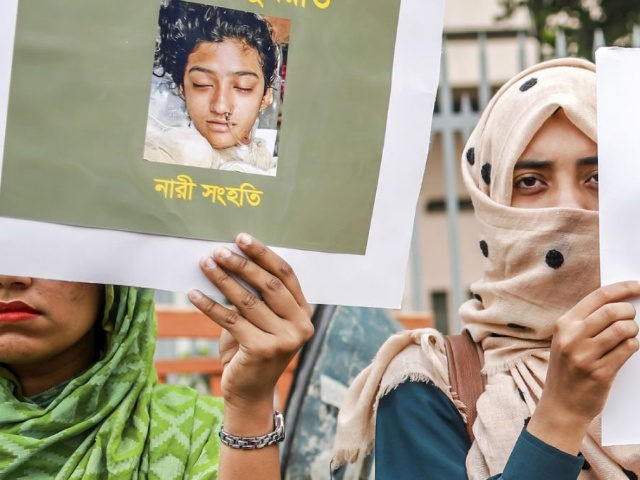 In this photo taken on April 12, 2019 Bangladeshi women hold placards and photographs of schoolgirl Nusrat Jahan Rafi at a protest in Dhaka, following her murder by being set on fire after she had reported a sexual assault. - A schoolgirl was burned to death in Bangladesh on the …