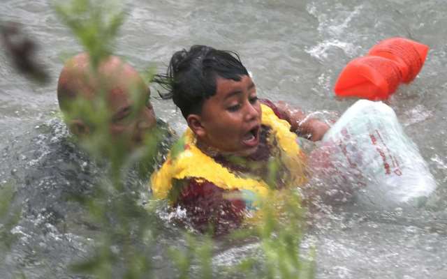 An Eagle Pass Border Patrol agents jumped into the Rio Grande to rescue a seven-year-old Honduran boy after he fall out of a makeshift raft. (Photo Bob Owen/San Antonio Express-News via AP)