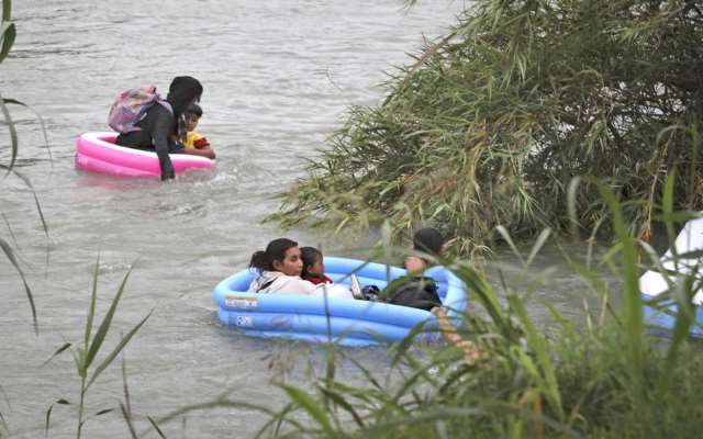 Three migrant rafts approach the U.S. bank of the Rio Grande after illegally crossing from Mexico. (Photo Bob Owen/San Antonio Express-News via AP)