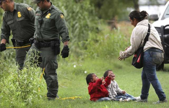 A Honduran mother runs to her crying babies after being rescued from a makeshift raft in the Rio Grande River. (Photo Bob Owen/San Antonio Express-News via AP)