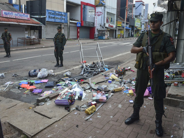 Sri Lankan security personnel stand guard outside a damaged shop after a mob attack in Minuwangoda on May 14, 2019. - A Sri Lankan province north of the capital was under indefinite curfew on May 14 after the first death in anti-Muslim riots in the wake of the Easter terror …