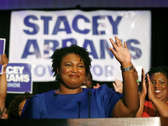 In this May 22, 2018, file photo Georgia's Democratic gubernatorial candidate Stacey Abrams waves in Atlanta. Abrams is trying to reach voters who don’t usually vote in midterm elections in the hopes to drive up turnout in her race against Republican Brian Kemp. (AP Photo/John Bazemore, File)