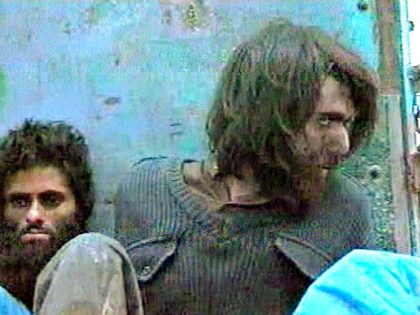 This file image taken Dec. 1, 2001, from television footage in Mazar-i-Sharif, Afghanistan, shows John Walker Lindh, right, claiming to be an American Taliban volunteer. (AP Video, File)