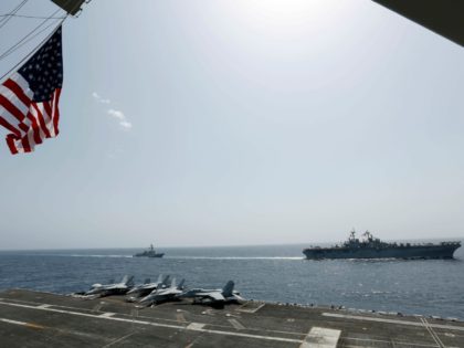 In this Friday, May 17, 2019, photo, released by the U.S. Navy, the amphibious assault ship USS Kearsarge, right, and the Arleigh Burke-class guided-missile destroyer USS Bainbridge, left, are seen from the Nimitz-class aircraft carrier USS Abraham Lincoln as they sail in the Arabian Sea. Commercial airliners flying over the …