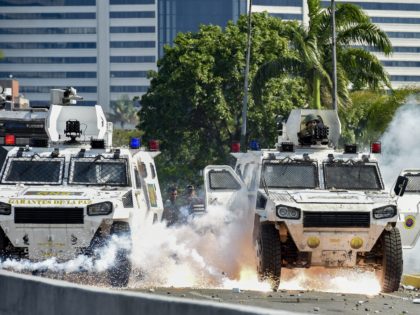 An explosion occurs under a military vehicle during clashes between forces loyal to Venezuelan President Nicolas Maduro and opposition demonstrators after troops joined opposition leader Juan Guaido in his campaign to oust Maduro's government, in Caracas on April 30, 2019. - Guaido -- accused by the government of attempting a …