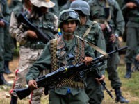 A Venezuelan army soldier carrying a squad machine gun (GPMG) attends the press conference given by Defence Minister general Vladimir Padrino Lopez at Fort Tiuna in Caracas on August 14, 2017.
