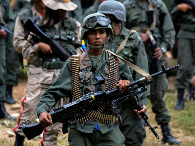 A Venezuelan army soldier carrying a squad machine gun (GPMG) attends the press conference
