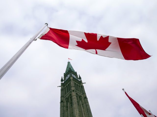 A Canadian flag flies in front of the peace tower on Parliament Hill in Ottawa, Canada on