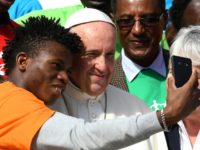 Pope Francis poses with a member of Caritas Internationalis during his weekly general audience at St. Peter's square in the Vatican on September 27, 2017. / AFP PHOTO / VINCENZO PINTO (Photo credit should read VINCENZO PINTO/AFP/Getty Images)