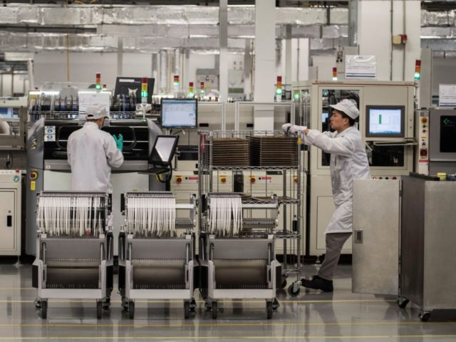 Workers are seen on the production line at Huawei's production campus on April 11, 2019 in