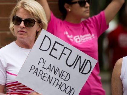 An opponent and supporter of Planned Parenthood demonstrate Tuesday, July 28, 2015, in Philadelphia. Anti-abortion activists are calling for an end to government funding for the nonprofit reproductive services organization. (AP Photo/Matt Rourke)