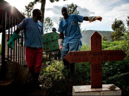 Health workers carry a coffin containing a victim of the Ebola virus on May 16, 2019 in Bu