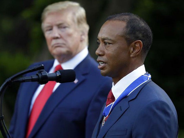 President Donald Trump listens as golfer Tiger Woods speaks after Trump awarded him the Pr