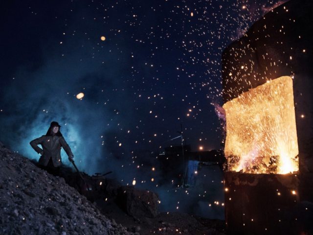 A Chinese labourer stands near a furnace as he works at an unauthorized steel factory on N